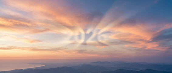 Fototapeta premium Beautiful Sunset Sky with 2026 Glowing in Sun Rays over Distant Hazy Landscape
