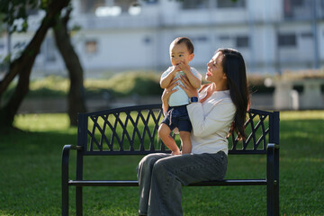 Asian mother bonding with toddler son in park