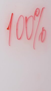 A person writes percentages on a white surface with a red marker. The handwriting is clear. Great for sale, discount, or special promotion announcements.
