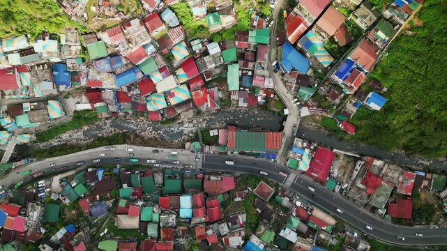 Aerial top-down view of busy road in the Valley of Colors with colorful residential, hillside rooftops - Baguio, Benguet, Philippines