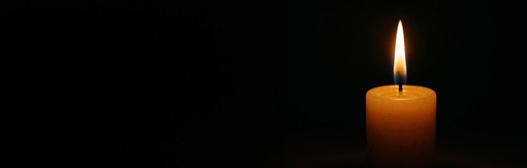 Single burning candle with glowing flame on dark black background with copyspace for memorial, mourning, or peaceful design concepts. Ai generative