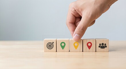 Market positioning and strategic location concept with businessman hand choosing yellow block from wooden cubes row featuring map pin icons, symbolizing target market selection, precise marketing, bus