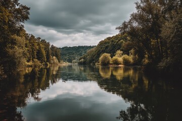 Scenic lake view reflecting forest beauty with an overcast sky and still water, capturing nature's tranquility and charm during a serene afternoon