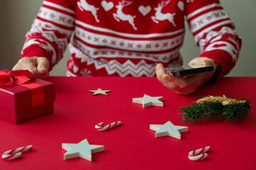 Midsection of senior woman holding a mobile phone with Christmas ornaments