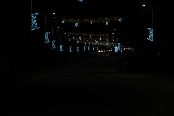 Festive Christmas street light decorations in bauble shape with artistic film grain on black...