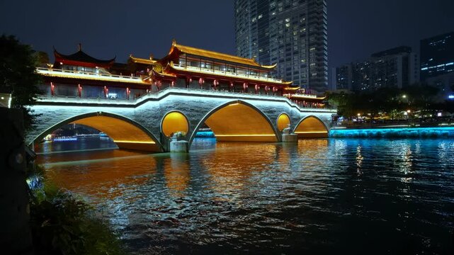 Beautifully illuminated anshun bridge reflecting in the jin river at night in chengdu, sichuan