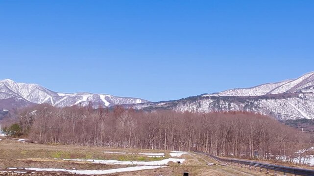 青空の下に広がる冠雪したばかりの初冬の磐梯山とネコママウンテンスキー場
