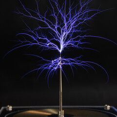 A bright electrostatic discharge from a Tesla coil with blue branching lightning bolts