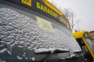 The windshield of a school bus in the snow. The inscription: children.