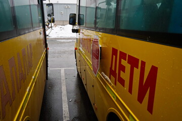 The inscription on the yellow school bus: Children. Parking space. Winter time, snowfall.