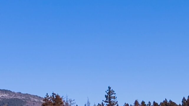 青空の下に広がる冠雪したばかりの初冬の磐梯山とネコママウンテンスキー場