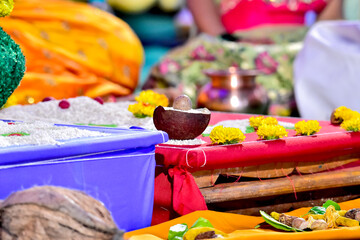 Close-up of traditional items arranged for Indian wedding ceremony, including rice, flowers,...
