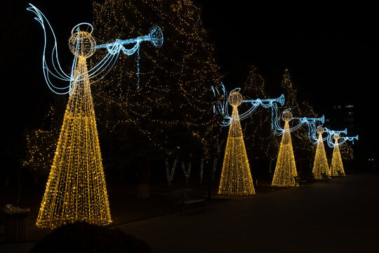 Christmas Angels Light Installations on a Pine Tree with Artistic Film Grain and Soft Focus at Night