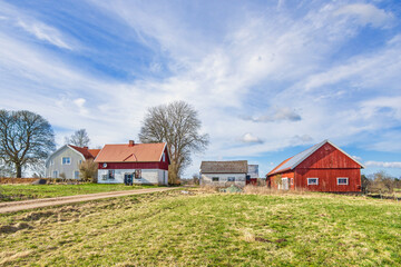 Farm in the countryside by a gravel road at spring