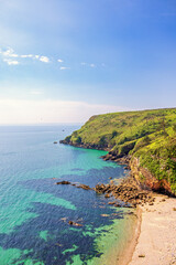 Obraz premium Rocky coastline with a sand beach in Bretagne a beautiful sunny summer day