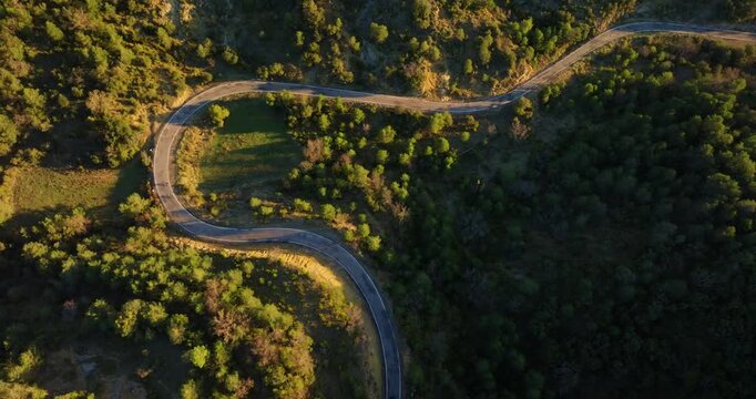 Top-down tracking shot of cyclists climbing the winding A-1604 mountain road toward Mirador de Fuebla in the Aragon Pyrenees, Spain, followed by tourist on camper van
