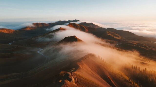 Aerial view of mountainous terrain with mist and clouds at sunrise - Powered by Adobe