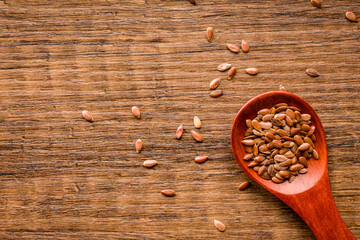 Brown linseed or flaxseed . Healthy flax seed on wooden spoon on wooden table. Top view.