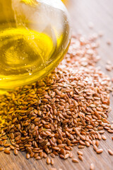 Brown linseed or flaxseed and oil. Healthy flax seed on wooden table.