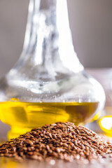 Brown linseed or flaxseed and oil. Healthy flax seed on wooden table.