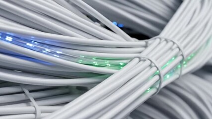 Data flowing through white fiber optic cables with glowing blue and green lights - High speed internet and network connection concept