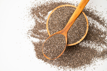 Chia seeds in wooden spoon and bowl on white background, top view. Organic, healthy seeds for digestion, source of omega-3 and protein. Superfood. Food background