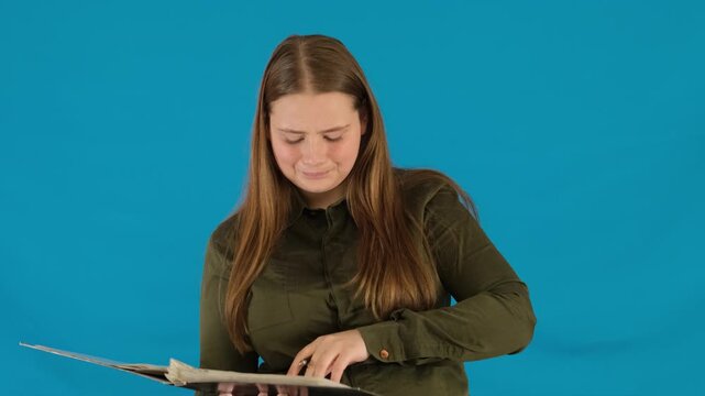 Pensive young woman takes out notes sticking on file in folder. Female student does cheat sheets for independent university work slow motion