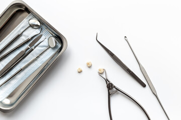 Many dental metal tools and teeth crows for implantation on white background. Professional Dentist desktop, top view