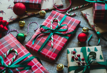 Close up of Christmas gifts wrapped in red and green with ribbons.