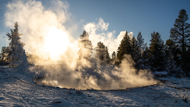 Sunset with mist rising from geologic formation in winter