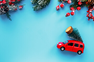 Red toy car with Christmas tree on the roof. Festive New Year concept