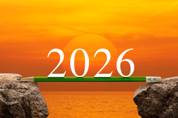 2026 white text on green pencil on rock mountain over sunset sky and sea, Business strategy and planning concept, Happy new year 2026 education concept
