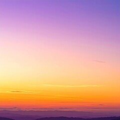 Sunset over a hazy mountain range.  Colors blend from vibrant orange and yellow at the horizon, softly transitioning through purples and violets in the sky above