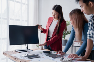 Asian business team collaborating on financial data analysis in office