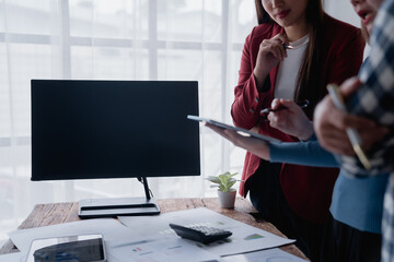 Businesswomen collaborating on desktop computer at office meeting