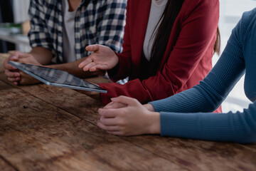 Business people having team meeting discussing data on digital tablet