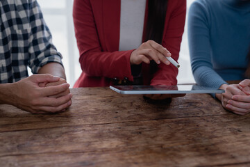 Colleagues collaborating using digital tablet at wooden table