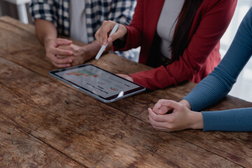 Business colleagues analyzing bar charts on a digital tablet