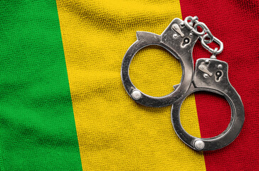 Flag of Mali and police handcuffs. Crime and offenses in country Concept
