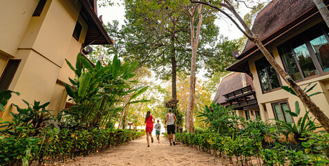 family running on the sandy path in tropical garden