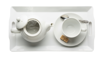 Close up overhead of a tray with a teapot, cup, and saucer arranged for afternoon tea isolated on white background
