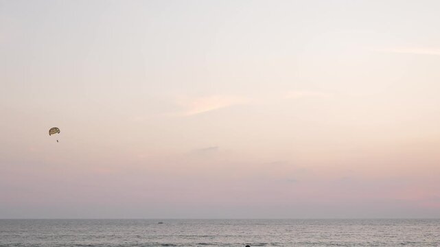 parasailing over sunset beautiful vanilla sky with some puffy cloud and beautiful colorful color in summer holiday vacation time,water outdoor sport activity at sunset time.4k sport summer background