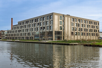 Modern temporary container housing complex in Utrecht located by the water, providing sustainable and modular living spaces for residents.