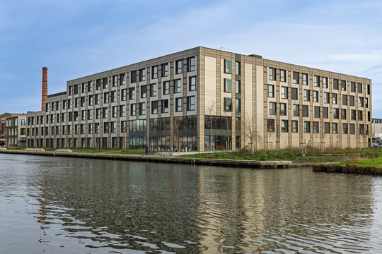 Modern temporary container housing complex in Utrecht located by the water, providing sustainable and modular living spaces for residents.