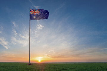 Fototapeta premium On flagpole in green field waving National flags of Australia