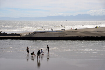 鵠沼海岸に流れ込む引地川河口でバレーボールで遊ぶ人達