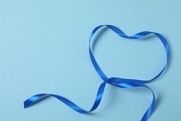 Curled blue ribbon on a colored background
