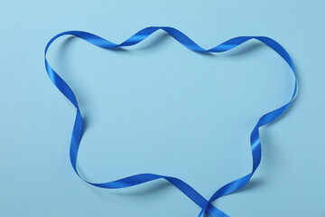 Curled blue ribbon on a colored background
