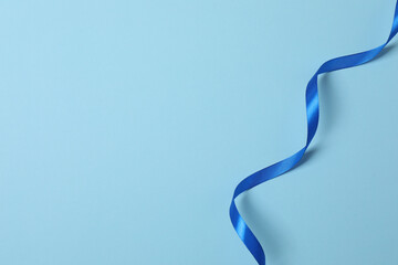 Curled blue ribbon on a colored background
