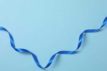Curled blue ribbon on a colored background
